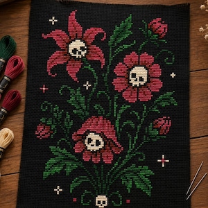 May include: A black cross-stitch fabric featuring a floral pattern with three large red flowers, each containing a white skull at its center. The design includes green leaves, stems, and small white cross-shaped stars scattered across the black background.