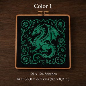 Könnte beinhalten: Kreuzstich-Stickerei mit einem grünen Drachen-Design auf schwarzem Hintergrund, in einem Holzrahmen. Der Text "Color 1" steht oben. Das Stück misst 22,0 x 22,5 cm und hat 121 x 124 Stiche.