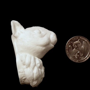 K&ouml;nnte beinhalten: Wei&szlig;e Keramik-Eichh&ouml;rnchenfigur mit detailliertem Gesicht und strukturiertem K&ouml;rper. Das Eichh&ouml;rnchen h&auml;lt einen Nusscluster in seinen Pfoten.