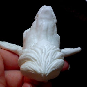 Op de afbeelding: Witte keramische sculptuur van een wolfskop met gedetailleerde vachttextuur.