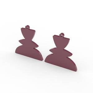 May include: Two maroon-colored, abstract-shaped earrings. Each earring has a rounded bottom, a tiered middle section, and a flared top with a small hole for hanging. The earrings are displayed against a white background.