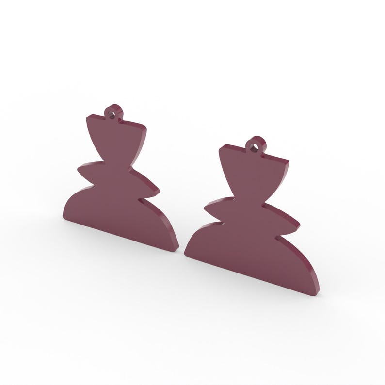 May include: Two maroon-colored, abstract-shaped earrings. Each earring has a rounded bottom, a tiered middle section, and a flared top with a small hole for hanging. The earrings are displayed against a white background.