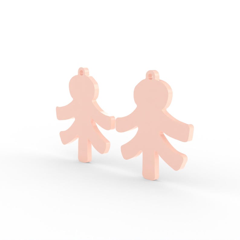 May include: Two light peach-colored, stylized human figure pendants. Each pendant has a loop at the top for hanging and outstretched arms and legs. The figures are standing upright, with a simple, minimalist design.