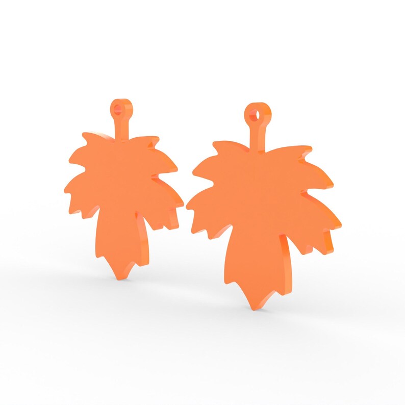 K&ouml;nnte beinhalten: Zwei orangefarbene Ahornblatt-Anh&auml;nger. Jeder Anh&auml;nger hat oben eine kleine Schlaufe zum Aufh&auml;ngen. Die Bl&auml;tter haben detaillierte Kanten und ein dreidimensionales Aussehen, was darauf hindeutet, dass sie aus einem festen Material bestehen.