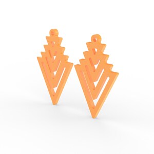 May include: Two orange geometric earrings with a layered, open design. Each earring features a series of stacked, inverted triangles, creating a unique, modern look. The earrings have a small loop at the top for hanging.