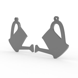 K&ouml;nnte beinhalten: Zwei graue Anh&auml;nger in Form einer Gie&szlig;kanne. Jeder Anh&auml;nger hat oben eine Schlaufe zum Aufh&auml;ngen und unten einen Ausguss. Die Anh&auml;nger sind einfarbig grau und vor einem wei&szlig;en Hintergrund platziert.