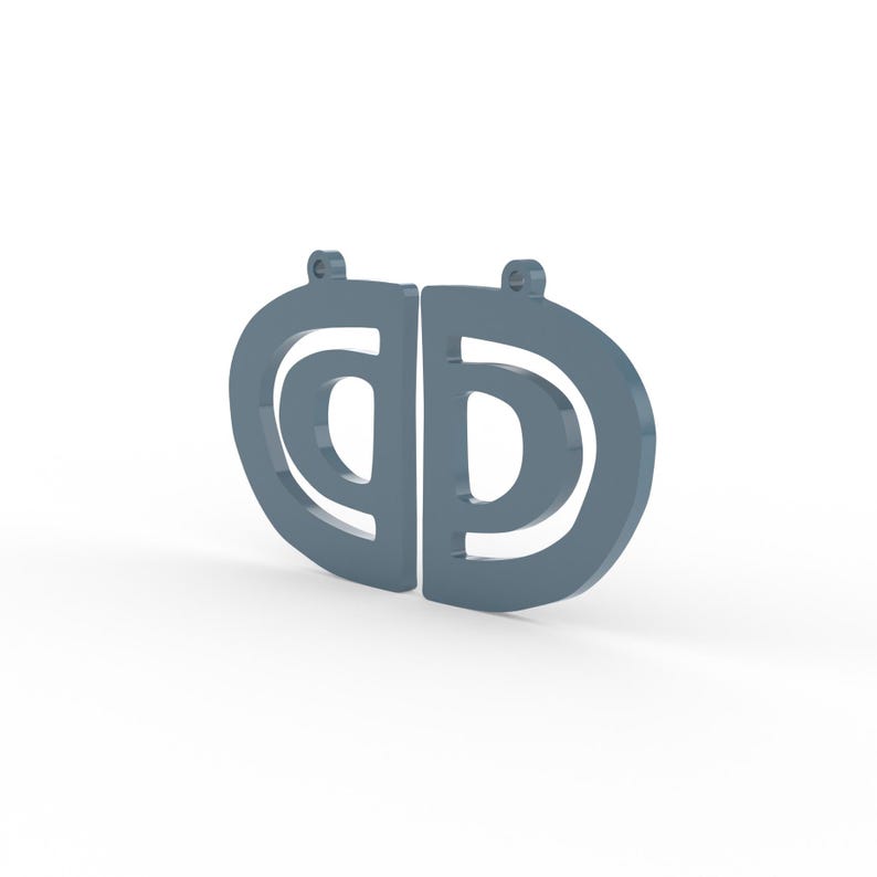 May include: Two matching gray earrings, each with a stylized letter "D" shape. The earrings have a rounded top with a small loop for hanging. The design features a negative space "C" within the "D" shape.