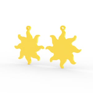Puede incluir: Dos dijes amarillos brillantes con forma de sol, cada uno con un cuerpo circular central con m&uacute;ltiples rayos ondulados radiantes y un peque&ntilde;o lazo circular en la parte superior para su fijaci&oacute;n. Los colgantes de sol son id&eacute;nticos.
