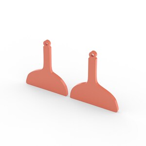 May include: Two coral-colored, abstract-shaped earrings with a small hole at the top for hanging. The earrings have a wide, curved bottom and a narrow, elongated top. The background is white.