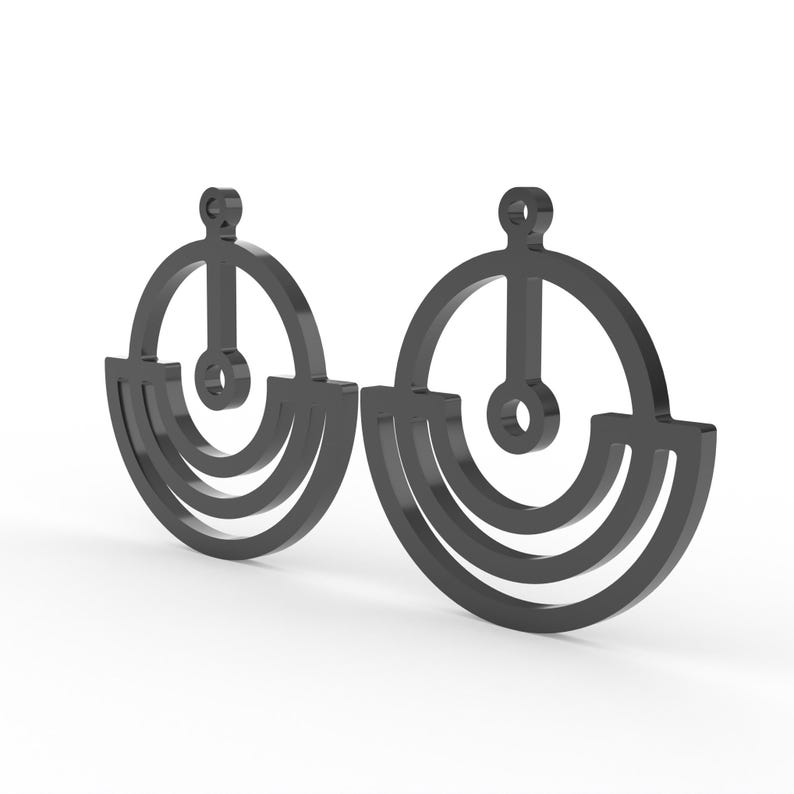 May include: A pair of dark gray earrings with a geometric design. Each earring features a circular top with a vertical bar and a small circle, connected to a semi-circular base with two curved lines. The earrings are displayed against a white background.