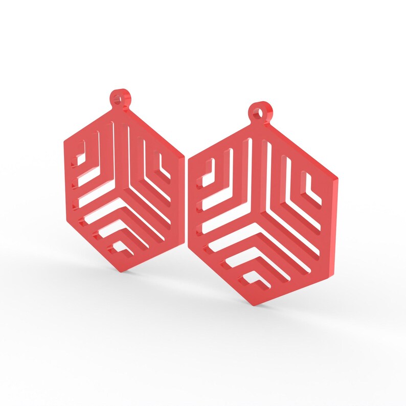 May include: Two red geometric earrings with a hexagonal shape and a cut-out design. Each earring has a small loop at the top for hanging. The earrings are displayed against a white background.