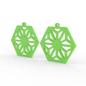 May include: Two lime green geometric earrings. Each earring is a hexagon shape with a snowflake-like design cut out of the center. The earrings have a small loop at the top for hanging. The earrings are displayed on a white background.