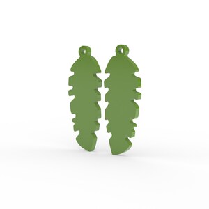 K&ouml;nnte beinhalten: Zwei olivgr&uuml;ne Ohrringe in Blattform. Jeder Ohrring hat oben eine Schlaufe zum Aufh&auml;ngen und eine Reihe von Aussparungen an den Seiten, die ihnen ein strukturiertes Aussehen verleihen. Die Ohrringe sind vor wei&szlig;em Hintergrund platziert.