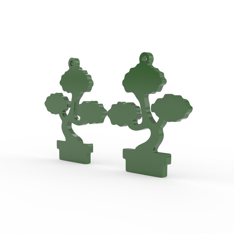 K&ouml;nnte beinhalten: Zwei gr&uuml;ne Ornamente in Form eines Bonsai-Baumes. Jedes Ornament zeigt einen Baum mit einer abgerundeten Krone und einem gebogenen Stamm, der in einem rechteckigen Topf steht. Die Ornamente sind oben mit einem Loch zum Aufh&auml;ngen versehen.