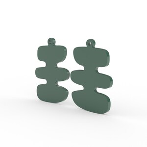 May include: Two green abstract earrings with a layered, organic shape. Each earring has a small loop at the top for hanging. The earrings are displayed against a white background.