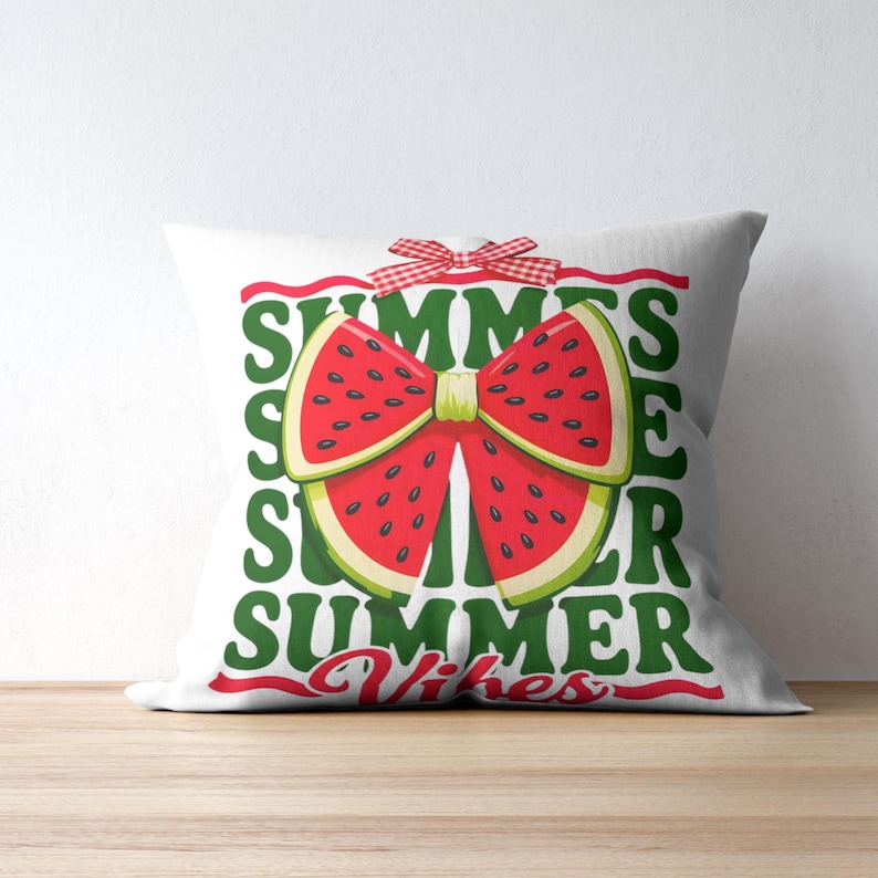 Op de afbeelding: Wit vierkant kussen met een watermeloen strik ontwerp. De strik is gemaakt van rode watermeloen schijfjes met zwarte pitjes en een groene schil. Het kussen heeft de woorden "SUMMER" en "Summer Vibes" in groen en rood.