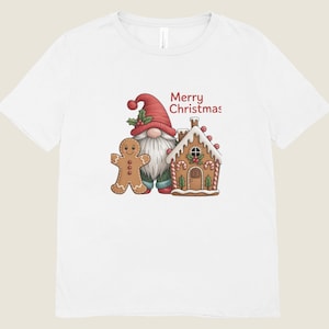 May include: White t-shirt featuring a Christmas gnome wearing a red hat and a gingerbread man. A gingerbread house with candy cane accents is also shown. The words "Merry Christmas" are printed in red.