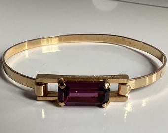 Pulsera rígida vintage Avon color dorado con pedrería morada, articulada, 15 cm, en perfecto estado.