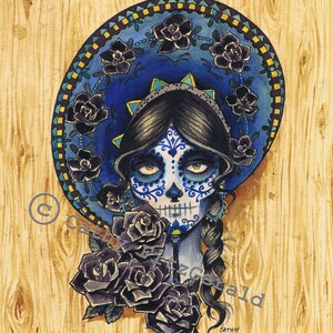 May include: A watercolor painting of a woman with a sugar skull face wearing a blue sombrero with black roses. The background is a wood grain texture. The artist's signature, Cathy Fitzgerald, is in the bottom right corner.