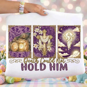 Può includere: Cuscino bianco con un design religioso con tre immagini incorniciate. Le immagini raffigurano un sepolcro vuoto, una croce e una figura con le braccia tese. Il testo "Death Could Not Hold Him" è sotto.