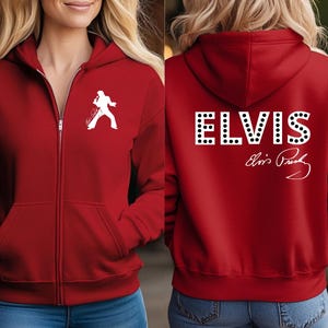 Pu&ograve; includere: Una felpa rossa con zip e cappuccio che presenta una sagoma bianca di Elvis Presley sul petto sinistro. Il retro mostra la parola ELVIS in grandi lettere bianche con puntini neri, accompagnata dalla firma bianca di Elvis Presley.