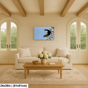 May include: A framed canvas print showing a bird in flight against a blue sky. The bird is brown and black, with its wings spread wide. The print is 61x91cm.