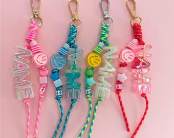 Dije para bolso con nombre personalizado, letras holográficas y paracord con cuentas con cierre giratorio de metal.