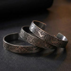 May include: A white ceramic mug with a black handle and the text "But First, Coffee" in a bold, black font. The mug is sitting on a wooden surface. The mug is approximately 4 inches tall.