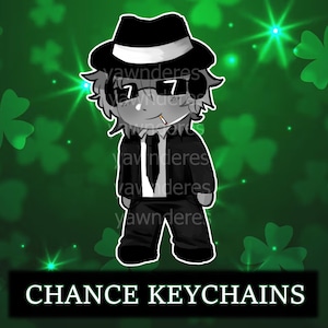 May include: A cartoon character keychain in a black suit, fedora, and sunglasses, with a cigarette in their mouth. The background is green with shamrocks and text that reads "CHANCE KEYCHAINS".