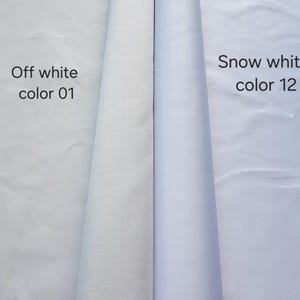 Puede incluir: Dos rollos de tela mostrados uno al lado del otro. El rollo de la izquierda est&aacute; etiquetado como Off white color 01, mostrando un tono blanco cremoso c&aacute;lido. El rollo de la derecha est&aacute; etiquetado como Snow white color 12, mostrando una superficie de tela blanca brillante, fr&iacute;a y n&iacute;tida.