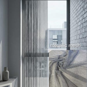 Puede incluir: Cortina de malla metálica gris claro frente a una ventana, con el texto "metallic mesh". La cortina está hecha de un material fino y tejido. Un primer plano muestra la textura de la tela. Ideal para la decoración de interiores.