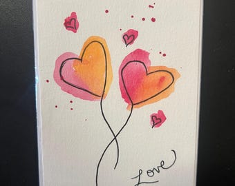 Puede incluir: Tarjeta de felicitación con dos corazones de acuarela en naranja y rosa, conectados por tallos negros. La palabra "Love" está escrita a mano en cursiva debajo de los corazones, con pequeños acentos de corazón y salpicaduras de pintura.