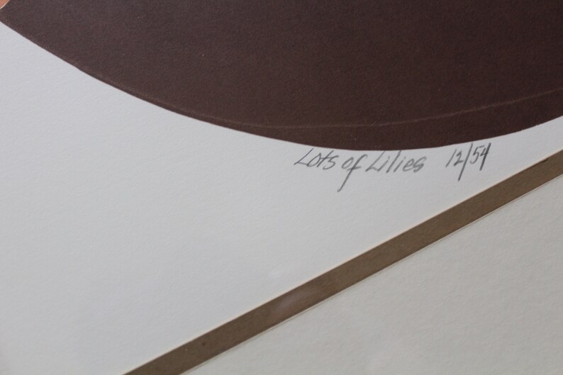 May include: A white paper with a brown circle and the text "Lots of Lilies 12/54" in black ink.