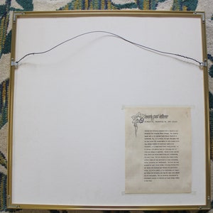 May include: A framed print with a gold frame and a white mount. The print features a black and white illustration of a flower with a text description of "Beverly Paul Letterer" and a short biography of the artist.