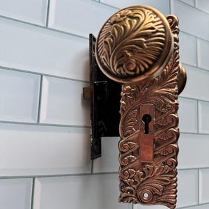 May include: A distressed wooden sign with the words "Welcome to our home" in white lettering. The sign has a rustic finish and a simple design, ideal for a front door.