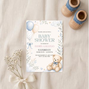 May include: A baby shower invitation with a teddy bear, balloons, and floral accents. The invitation reads "Baby Shower" and includes the name Daniel Gallego, date, time, and RSVP information. Wooden baby shoes are placed above the invitation.
