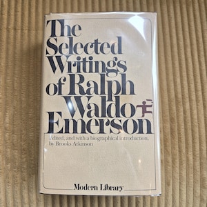 May include: A hardback book titled "The Selected Writings of Ralph Waldo Emerson" by Brooks Atkinson. The book has a beige cover with black text and is from the Modern Library series. The book is in a clear plastic wrapping.