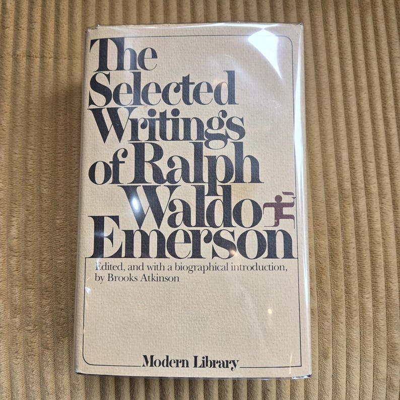 May include: A hardback book titled "The Selected Writings of Ralph Waldo Emerson" by Brooks Atkinson. The book has a beige cover with black text and is from the Modern Library series. The book is in a clear plastic wrapping.