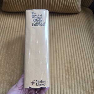 May include: A hardback book titled "The Selected Writings of Ralph Waldo Emerson" with a tan cover and the Modern Library logo. The book is wrapped in clear plastic. The book is in good condition.