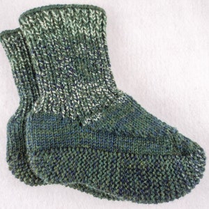 Puede incluir: Un par de calcetines de punto verde y blanco con un patrón texturizado.