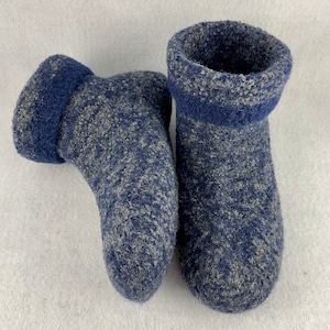 May include: A pair of blue and gray fuzzy slipper socks. The socks have a fold-over cuff.