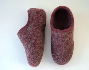 Puede incluir: Un par de zapatillas de lana afieltrada en una mezcla moteada de color burdeos intenso y gris jaspeado. Las zapatillas presentan una puntera redondeada, un talón alto y una construcción gruesa y texturizada con un diseño sin costuras.