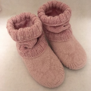 Puede incluir: Un par de pantuflas de punto rosa con textura esponjosa.