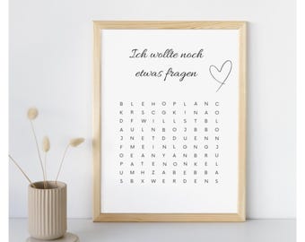 May include: A framed print with the text "Ich wollte noch etwas fragen" and a heart symbol. Below the text is a word search puzzle. A beige vase with dried flowers is on the left.