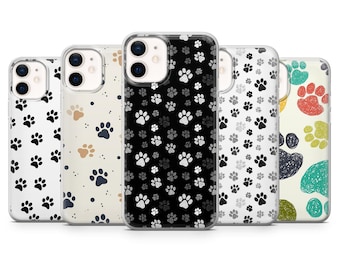 May include: A collection of five phone cases with paw print designs. The cases feature various color schemes, including black and white, tan and black, and colorful paw prints. The cases are designed to fit a smartphone.