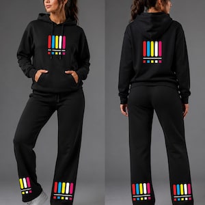 May include: A black hooded sweatshirt and matching black sweatpants. The hoodie features a front graphic of five vertical bars in yellow, white, and pink, with smaller horizontal bars below. The sweatpants display the same graphic on the lower leg.