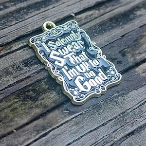 Op de afbeelding: Een rechthoekige hanger met de tekst "I Solemnly Swear That I'm Up to No Good" in witte letters op een zwarte achtergrond. De hanger heeft een goudkleurige rand en een kleine lus aan de bovenkant om aan een ketting of sleutelhanger te bevestigen.