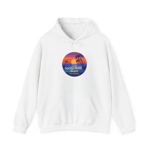 May include: White hoodie with a front pocket and drawstring. It displays a circular graphic of a sunset, palm trees, and the text "Santa Rosa Beach Gulf of Mexico". The design is printed on the front.