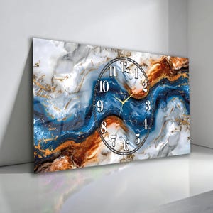 May include: Rectangular wall clock with a marble design in shades of blue, white, and gold. The clock face is a classic round shape with black numerals and gold hands. The clock is mounted on a white wall.