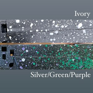 Pu&ograve; includere: Due immagini ravvicinate di una superficie nera con schizzi di vernice bianca e colorata. L'immagine superiore &egrave; etichettata "Avorio" e l'immagine inferiore &egrave; etichettata "Argento/Verde/Viola".
